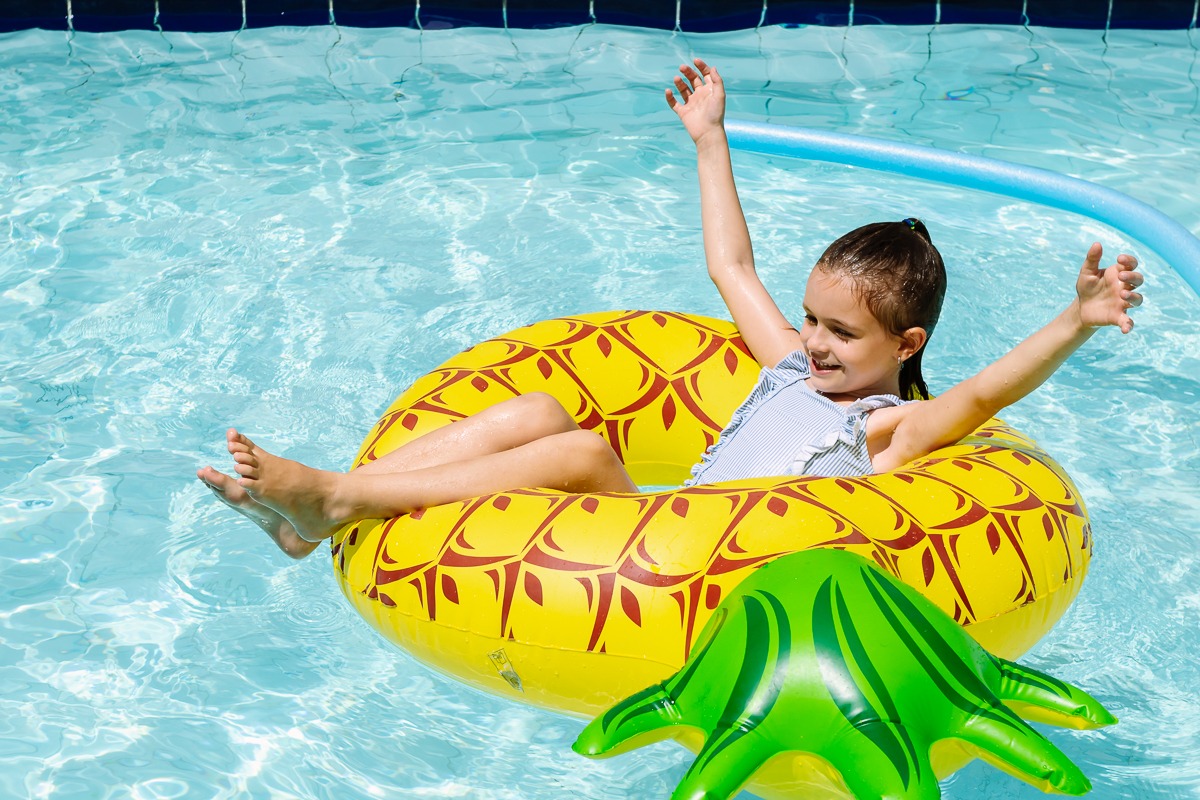 Criança na piscina dentro de uma boia.